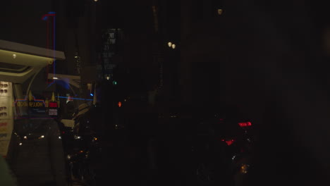 Cinematic-shot-of-window-reflecting-a-busy-Hollywood-Blvd-night-in-slow-motion