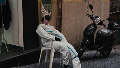 Surreal-street-mannequin-resting-on-a-chair,-Neapolitan-alley,-Italy