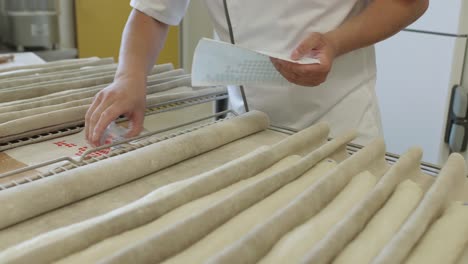 Worker-Doing-Quality-Control-Check-On-Fresh-Rolled-Dough-At-Bread-Factory
