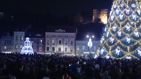 Gente-Esperando-El-Año-Nuevo,-En-La-Plaza-De-La-Ciudad-De-Brasov-Con-Un-árbol-De-Navidad,-Rumania
