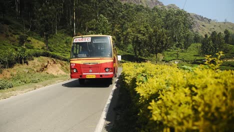 Passenger-Bus-And-Cars-Driving-On-The-Mountain-Road-In-Munnar,-Kerala,-India-Surrounded-In-Tea-Plantations