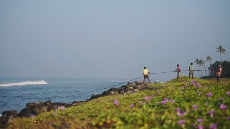 Los-Pescadores-Locales-Tirando-De-Redes-De-Pesca-Tradicionales,-Kappil-Beach,-Varkala,-India