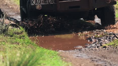Slow-motion-of-a-safari-vehicle-on-a-wet-muddy-road,-Aberdare-National-Park,-Kenya
