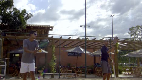 A-player-jumps-into-the-air-for-a-serve-in-beach-tennis