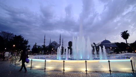 Time-lapse-of-the-Blue-Mosque,-Istanbul,-Turkey,-behind-fountains,-on-a-cloudy-evening