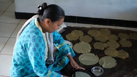 Side-view-of-Indian-woman-weaving-papadam