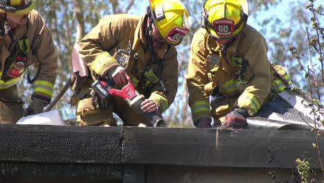 firefighters-use-tools-to-cut-into-building
