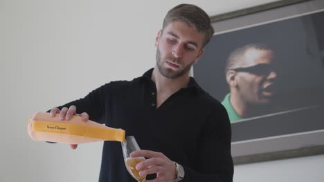 Slow-motion-shot-of-an-attractive-man-pouring-alcohol-into-a-champagne-glass