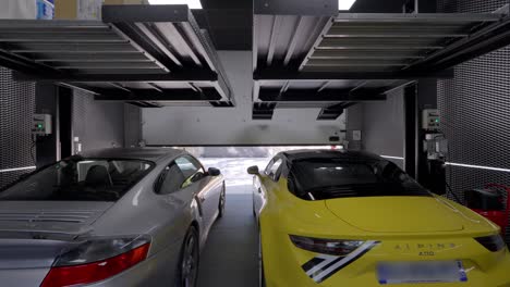 Automatic-garage-door-opener-and-a-woman-entering-between-two-parked-sports-cars