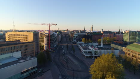 Aerial-view-overlooking-the-quiet-Mannerheimintie-street-and-the-downtown-of-Helsinki,-sunny,-summer-morning-sunrise,-in-Toolo,-Helsingfors,-Uusimaa,-Finland---rising,-drone-shot
