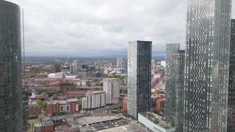 Manchester-Deansgate-aerial-view-flying-between-modern-city-centre-skyscrapers-overlooking-downtown-skyline