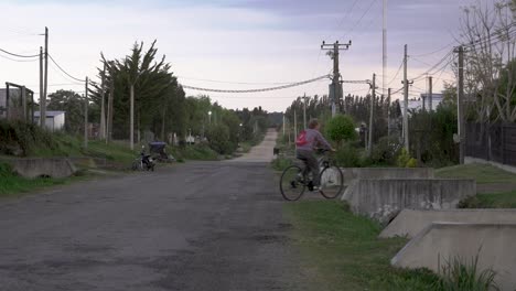 Anciana-Andando-En-Bicicleta-En-Un-Antiguo-Barrio-De-Un-Pueblo-Rural