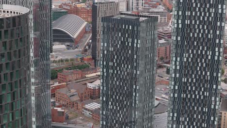 Manchester-Deansgate-Vista-Aérea-De-Cerca-Orbitando-Rascacielos-De-Vidrio-Geométricos-Altos-Contemporáneos