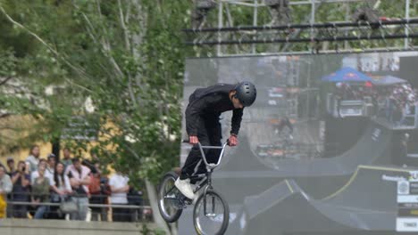 A-boy-at-the-skate-park-performs-daring-tricks-on-a-bicycle,-soaring-high-above-the-ground-with-impressive-stunts