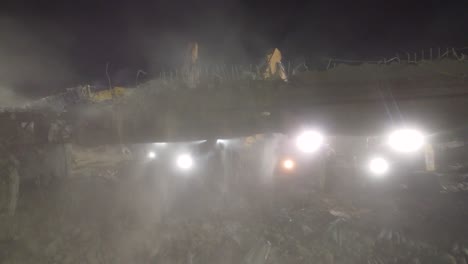 Tracking-shot-over-jackhammer-heavy-machinery-working-on-Demolition-of-Sunnivale-bridge,-Highway-400-at-Night