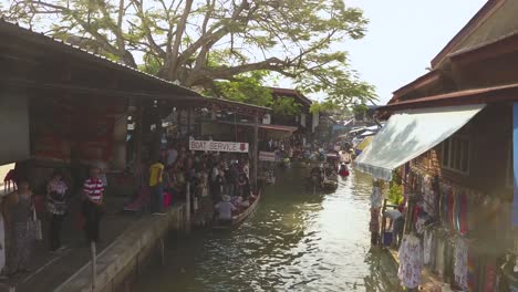 Drohnen-Luftaufnahme-Des-Lebhaften-Schwimmenden-Marktes,-Thailand,-Geschäfte,-Menschen,-Boote-Auf-Einem-Authentischen-Marktplatz-In-Der-Thailändischen-Landschaft