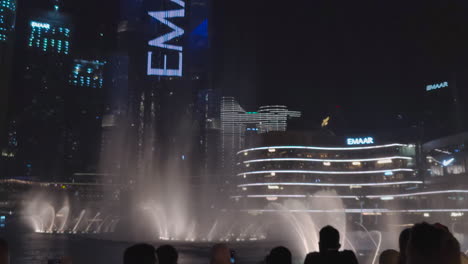 Tourists-with-smartphones-watching-the-Dubai-Fountain-show-in-May-2021-in-UAE-in-front-of-the-Burj-Khalifa-at-night