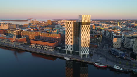 Aerial-view-of-the-Clarion-Hotel-building,-on-a-sunny-morning-sunrise,-in-Jatkasaari,-Helsinki,-Finland---dolly,-drone-shot