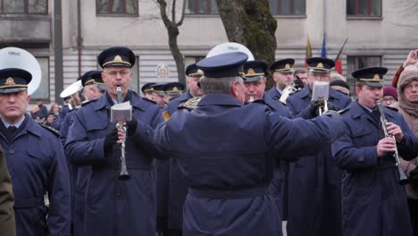 Watching-a-conductor-direct-a-military-band-standing-on-display-in-Kaunas,-Lithuania-for-the-Restoration-of-the-State-and-Vasario-celebration