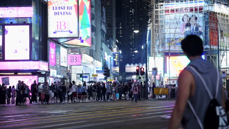 Crowds-of-people-crossing-a-busy-street-during-the-night-in-Hong-Kong---time-lapse