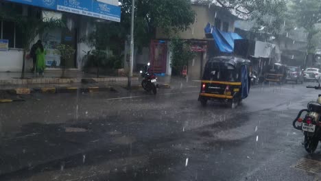 Ciclista-Con-Impermeable-Y-Rickshaw-Durante-Las-Fuertes-Lluvias,-Mumbai,-India