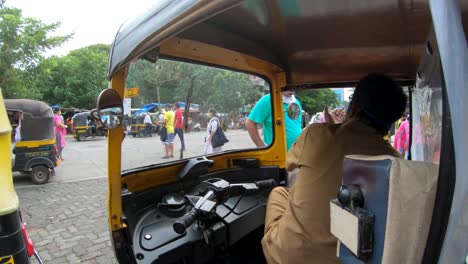 Conductor-De-Un-Vehículo-Tuk-tuk-Hablando-Mientras-Espera-A-Un-Pasajero-En-Mumbai,-India---Cámara-Lenta