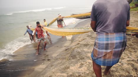 Local-people-fishing-with-traditional-fishing-nets,-Kappil-Beach,-Varkala,-India