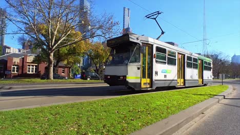 Melbourne-tram-travelling-along-St-Kilda-Road-with-city-buildings-and-spire-in-background