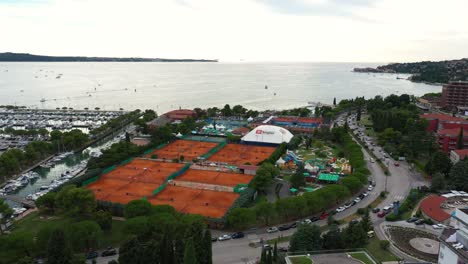 Forward-drone-aerial-flying-over-seaside-coastal-town-of-Portoroz---ATP-Challenger-Slovenia-Open-tennis-grounds
