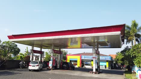 Establishing-Static-Shot-of-Pertamina-Oil-Petrol-Gas-Station-in-Bali-Indonesia-Daylight,-Red-Roof,-Cars-and-Scooters,-Denpasar-Area,-Sanur