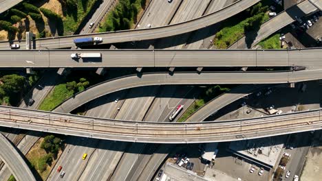 Top-down-drone-shot-of-traffic-passing-through-Seattle's-freeway-system-on-a-sunny-day