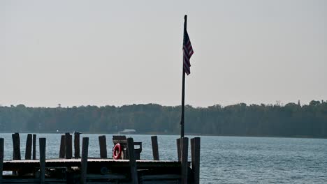 American-Flag-on-end-of-dock-in-Hessel-Michigan,-Lake-Huron