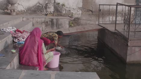 Indische-Frauen-Am-Teich,-Eingetaucht-In-Die-Zeitlose-Tradition-Des-Wäschewaschens