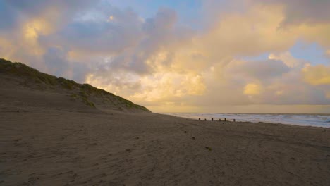 Sandstrand-Unter-Einem-Himmel-Mit-Kontrastierenden-Wolken-Bei-Sonnenuntergang