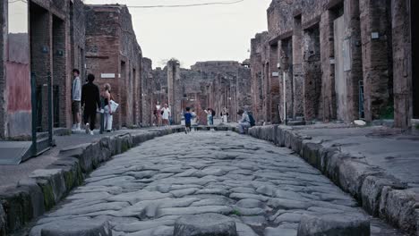 Ancient-streets-of-Pompeii-with-visitors,-Italy