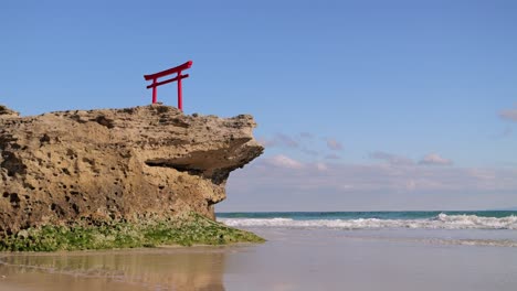 Calm-minimalist-scenery-at-ocean-with-Japanese-Torii-gate-on-top-of-rock-cliff