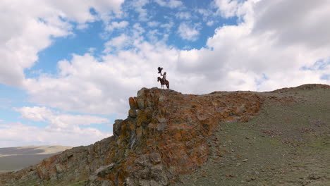 Asian-Hunter-On-A-Horse-On-Clifftop-Holding-Eagle-In-Western-Mongolia
