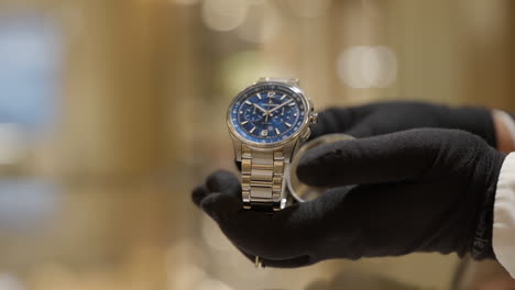 Eine-Luxuriöse,-Modische-Boutique-Armbanduhr,-Die-Von-Behandschuhten-Händlerhänden-Zur-Schau-Gestellt-Wird