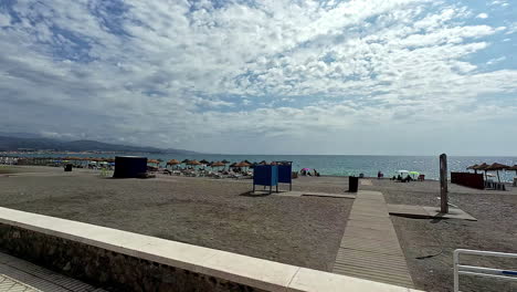 The-beachfront-at-Spain-Malaga-is-breathtaking,-with-lounge-chairs-and-umbrellas-overlooking-the-expansive-ocean