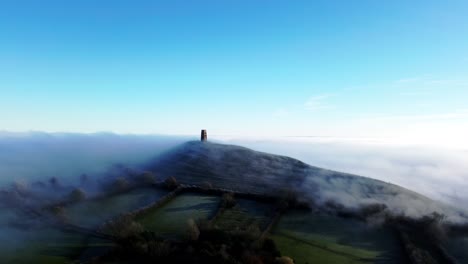Wide-shot-of-Glastonbury-Tor-with-mist-rising-around-it