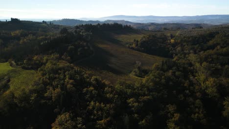 Orange-rote-Herbstlich-Gefärbte-Bäume-In-Der-Toskana-Werfen-Lange-Schatten-Auf-Die-Hügellandschaft-Und-Bieten-Wunderschöne-Ausblicke-Auf-Die-Italienische-Landschaft