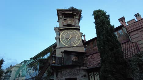 Golden-hands-of-clock-tower-in-Tbilisi-the-asymmetric-building-made-by-old-city-ruins-by-modern-art-architect-in-down-town-old-city-of-Tiflis-walking-tour-tourist-attraction-landmark-scenic-shot