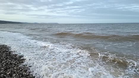 Sandy-waves-slow-motion-crash-onto-Llandudno-pebble-beach