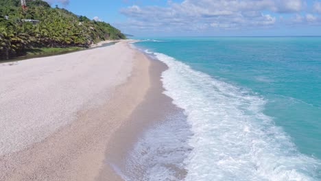 Waves-of-Caribbean-sea-reaching-playa-Los-patos-in-barahona-at-sunny-day