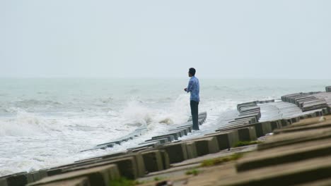Thoughtful-man-standing-in-a-dam-and-staring-at-the-ocean