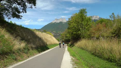Los-Ciclistas-Viajan-Por-El-Carril-Bici-Cerca-Del-Lago-De-Annecy.