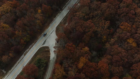 Car-Driving-On-A-Highway-Road-In-Between-Autumn-Forest-In-AR,-USA---Drone-Shot