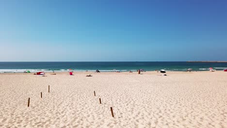 Sunbathing-people-at-Praira-da-Barra-beach-in-autumn-from-Gafanha-da-Nazaré,-Portugal