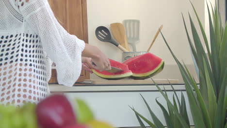 Eine-Frau-Schneidet-In-Der-Küche-Mit-Einem-Großen-Messer-Das-Fruchtfleisch-Einer-Reifen-Wassermelone