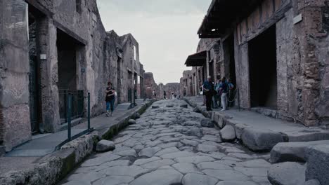 Turistas-Explorando-Las-Calles-Adoquinadas-De-La-Antigua-Pompeya,-Italia.